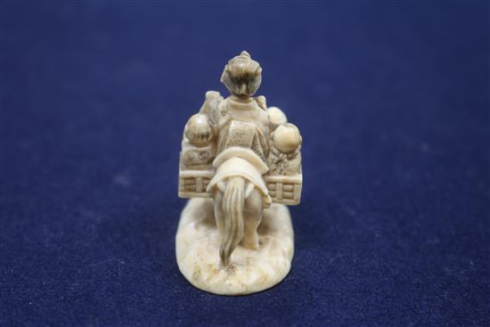 A Japanese carved ivory group of a family travelling with a donkey, height 43mm.